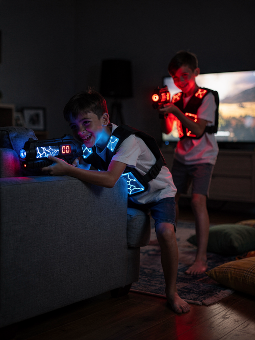 Kids playing glow-in-the-dark laser tag in the living room